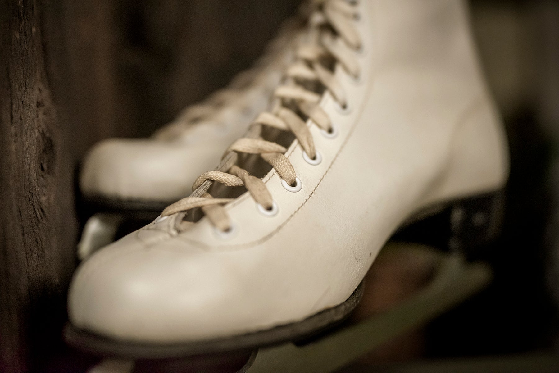 A pair of old figure skates hang in a museum