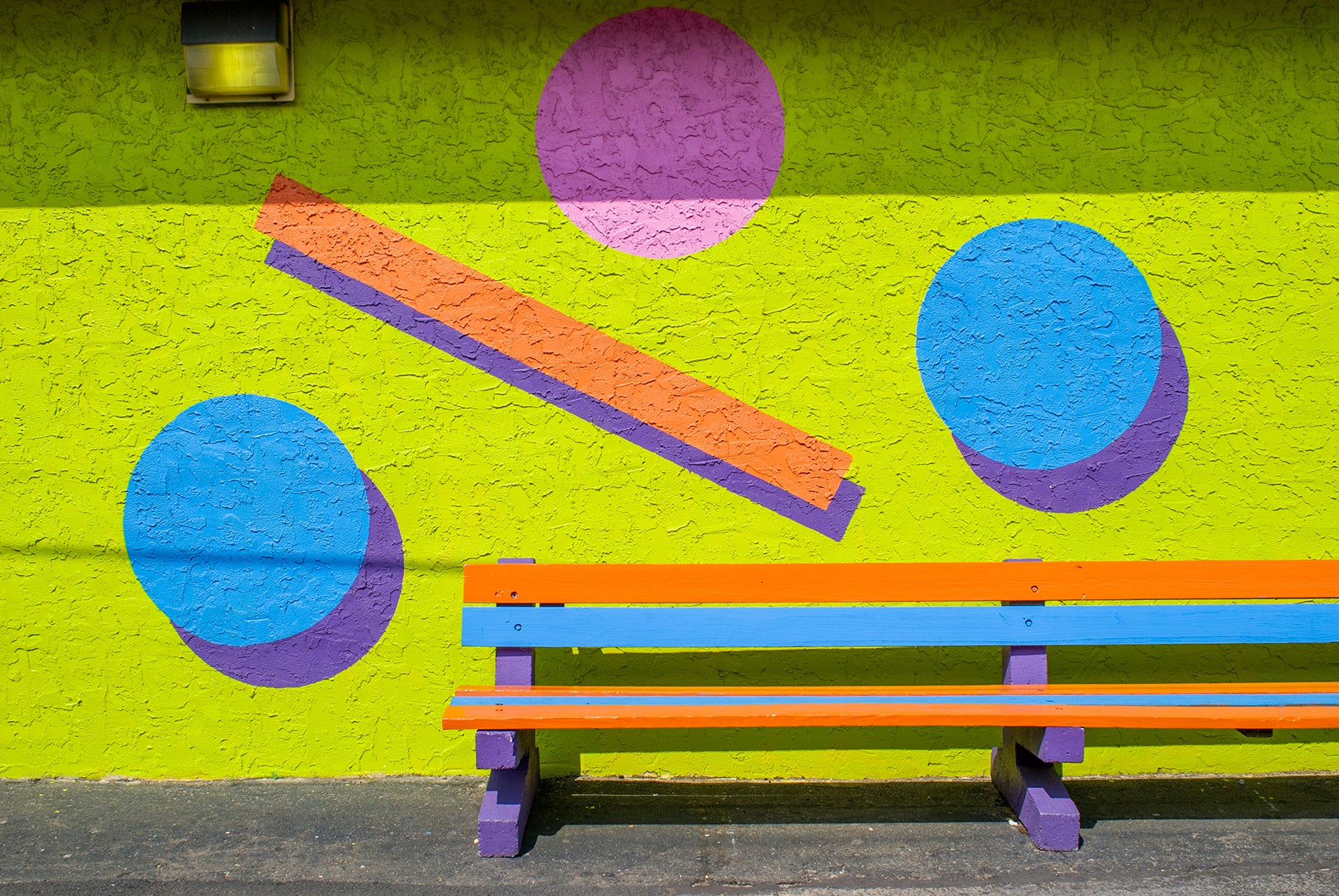 A neon colored bench at an amusement park